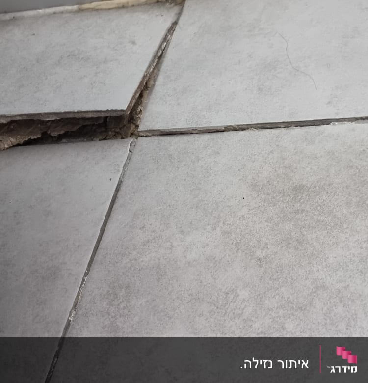 אריח רצפה שבור עם חשיפת תשתית מתחת